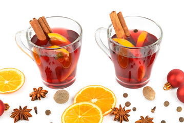 Hot red mulled wine isolated on white background with spices, orange slice, anise and cinnamon sticks. Flat lay, top view.