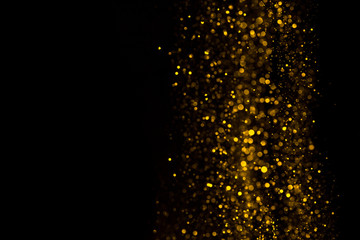 Falling glitter dust bright bokeh border on black background with copy space