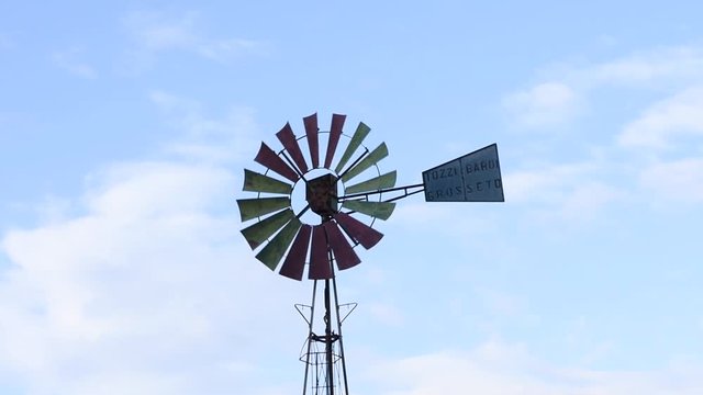 A vintage windmill spins with the wind. Selective focus video