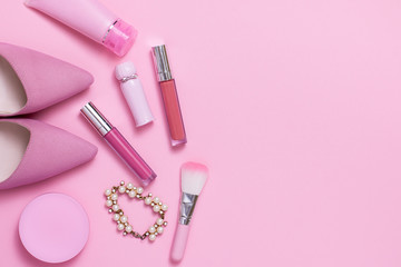 Layflat image of pink womans fashion and cosmetics products.