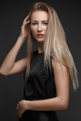 Fototapeta premium sexy fashion model with long hair, young European attractive, beautiful eyes, perfect skin is posing in studio for glamour vogue test photo shoot showing different poses. Picture taken in the studio