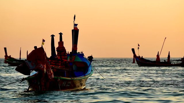 Travel video silhouette long tail boat and The fisherman are maintenance ship. After the boats go out, such as catching the fish. Trips are made every day with  golden light of the Sun  before sunset