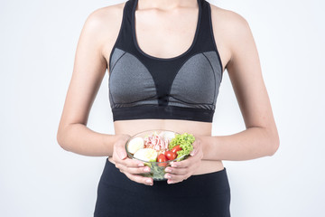 Fitness and health concept. Portrait of fit sport woman holding green salad bowl, isolated on white background. Chinese woman with black tank top and pants.