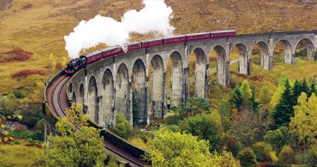 Aerial view of Steam Train crossing Glenfinnan Viaduct Scotland