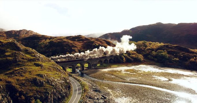 Aerial view of Steam Train crossing Glenfinnan Viaduct Scotland
