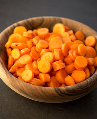 Chopped carrot in circles in wooden bowl