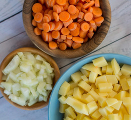 Top view of various vegetables cut in small pieces prepared for veggie soup cooking.