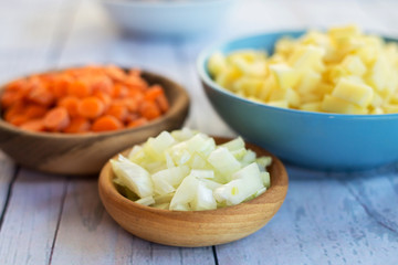 Top view of various vegetables cut in small pieces prepared for veggie soup cooking.