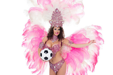 woman in carnival costume with pink feathers holding football ball, isolated on white