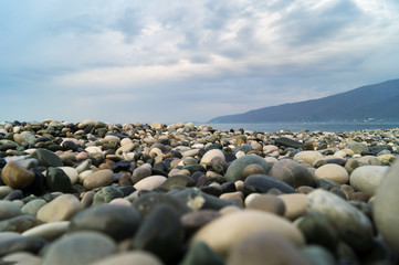 Морская галька на берегу Черного моря, небо в тучах, утро.