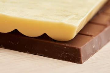 white porous chocolate lies on the black chocolate closeup