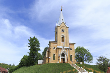view from below of the roman catholic church in the district Steierdorf of the romanian mining village Anina on a hill