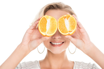 beautiful smiling young woman holding halves of orange near face isolated on white
