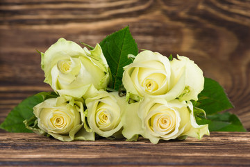 bouquet of white fresh roses on a dark wooden background