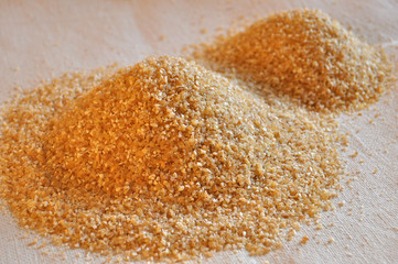 Two piles of wheat grain on the background of sackcloth.