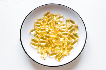 plate with capsules of fish oil close-up