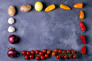 Top view of delicious ingredients for healthy cooking or salad making on slate vintage background. Bio Healthy food, herbs and spices. Organic vegetables on slate. Cooking or vegetarian food concept.