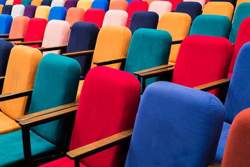 The auditorium in the theater. Multicolored spectator chairs.