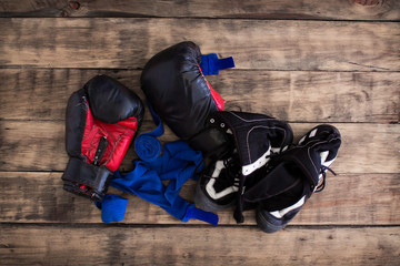 Old Black Boxing Gloves on  Vintage Wooden Grunge Background Copy Space.