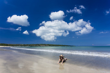 Woman laying on water's edge at Jimbaran Beach, Bali