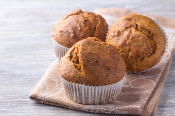 Pumpkin muffins with poppy seeds and cinnamon on a wooden table. Delicious homemade food