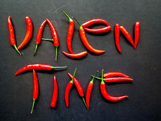 Red pepper chili design in letter word Valentine on black background, spicy tasty, Valentine's day...