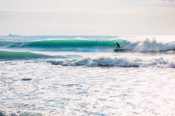 Fototapeta na wymiar Surfer on blue barrel wave. Winter surfing in ocean