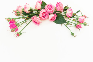 Spring composition with pink roses on white background. Top view. Flat lay. Floral frame of flowers, copy space