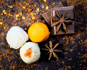 Truffles, chocolate bar, star anise and pepper on a dark background