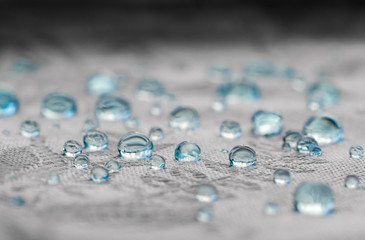 Blue drops on water resistance surface of textile fabric fibers. Macro 