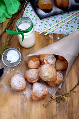 French doughnuts Beignet covered with sugar powder on a wooden table