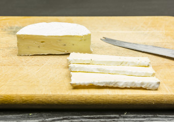 Tasty Camembert cheese on a chopping board.