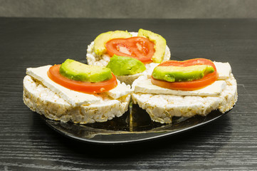Healthy and dietary sandwiches - rice cake with cheese, tomato and avocado.
