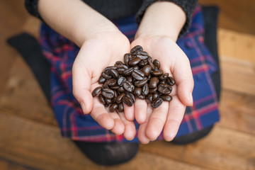 コーヒー豆を持った子供の手