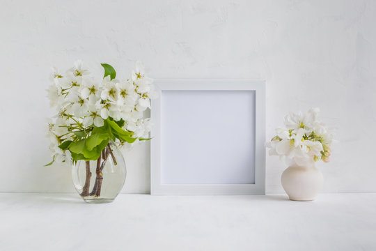 Mockup with a white frame and white flowers