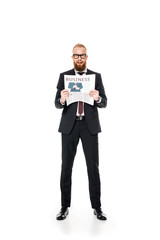bearded young businessman in eyeglasses holding newspaper and looking at camera isolated on white