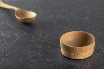 empty wooden dish and spoon on a black background