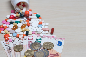 Different pills and banknotes are money euros. A symbol of expensive medical care and medical insurance.