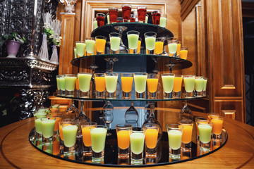 Green and orange cocktails stand on the bar