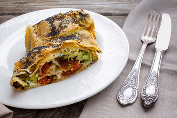 Strudel with cheese and sun-dried tomatoes. Homemade pie, strudel and snacks