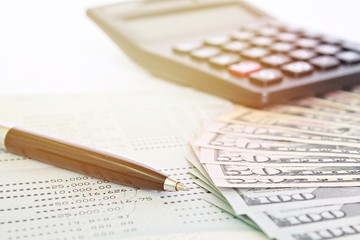 Business, finance, investment, savings or accounting concept : American Dollars cash money, calculator and savings account passbook or financial statement on table