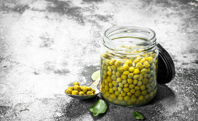 Marinated green peas in glass jar.