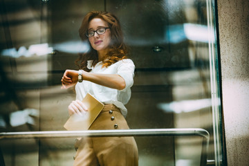 Businesswoman checking watch while standing in elevator © NDABCREATIVITY