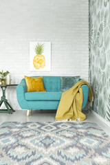 Yellow blanket on turquoise sofa