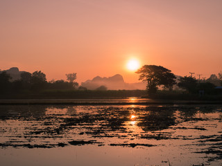 Front view of the meadow, mountains and sunset.