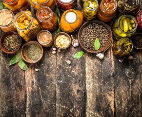 Different preserved vegetables from vegetables and mushrooms in glass jars.