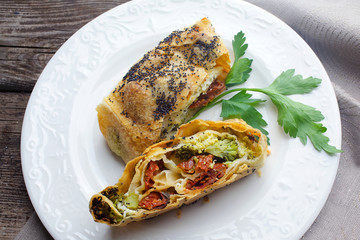 Strudel with cheese and sun-dried tomatoes. Homemade pie, strudel and snacks