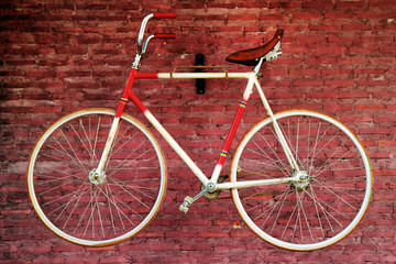 Old bicycle on a background of red brick wall. Bangkok, Thailand.