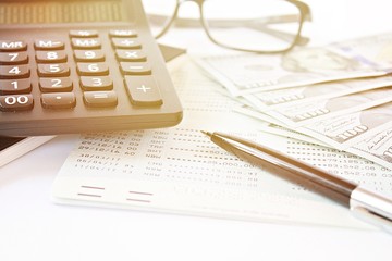Business, finance, investment, accounting or money exchange concept : American Dollars cash money, calculator on savings account passbook or financial statement