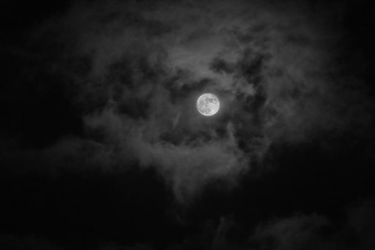 Full moon in the sky with clouds at night. Real Photos